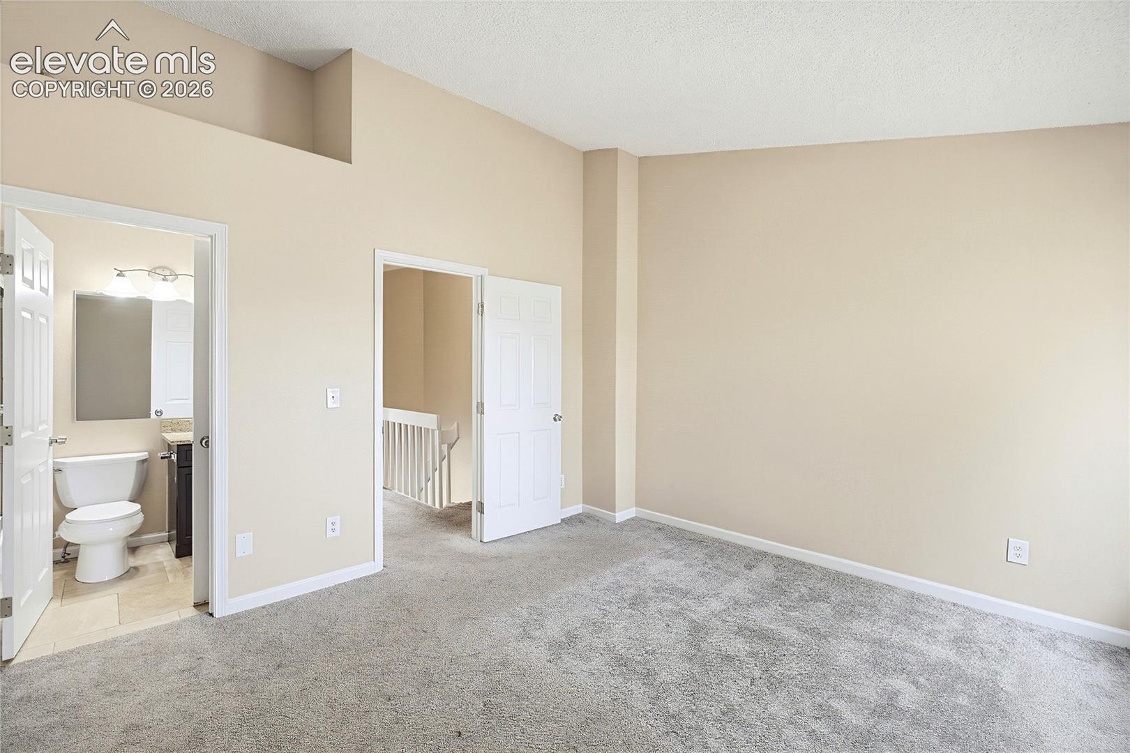 The vaulted Primary Bedroom has neutral carpet, double closets, and an adjoining Full Bathroom.