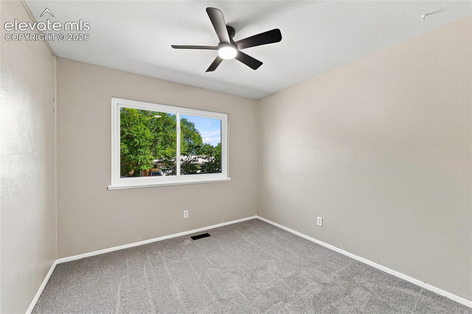 Neutral-toned walls, carpeted flooring, and a modern ceiling fan with integrated lighting