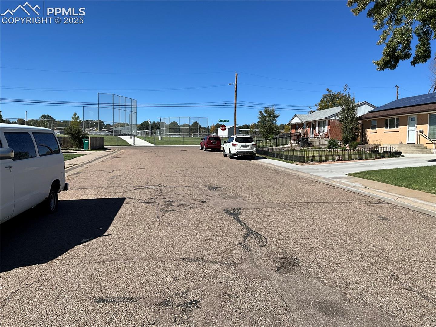 View of asphalt road featuring sidewalks, curbs, and a residential view