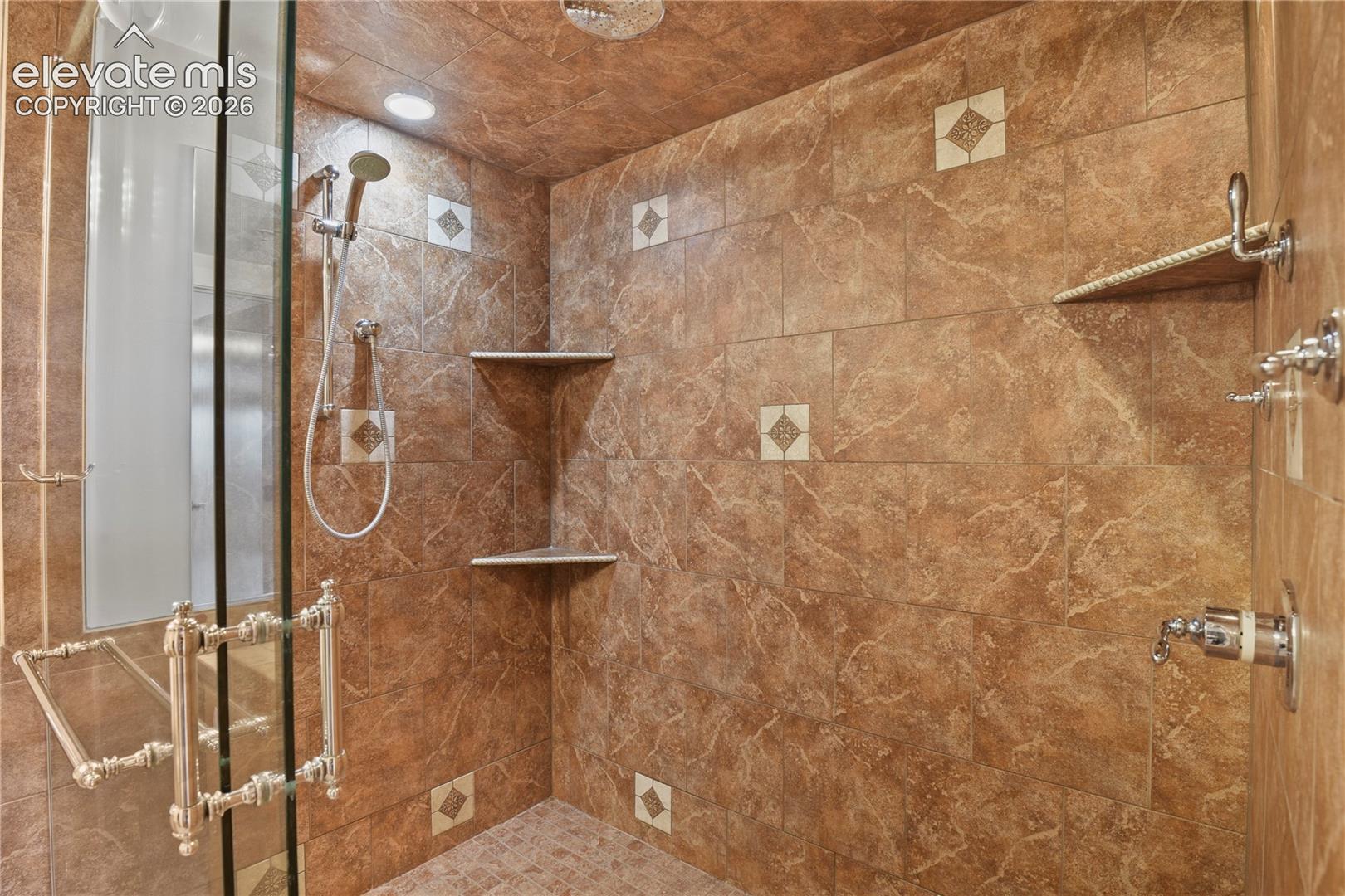 Oversized walk-in shower with a frameless European glass enclosure & multiple shower heads