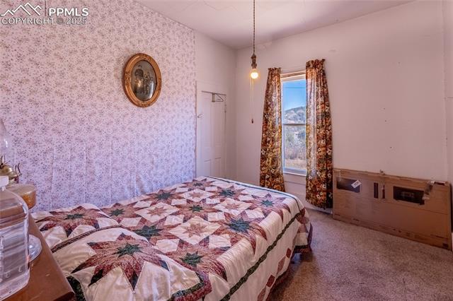 Bedroom featuring carpet and wallpapered walls