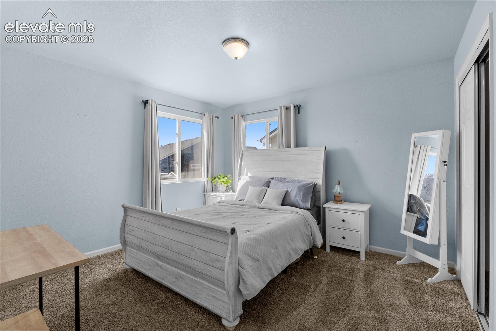 Plush carpet flooring, a built-in closet with sliding doors, and a ceiling-mounted light fixture