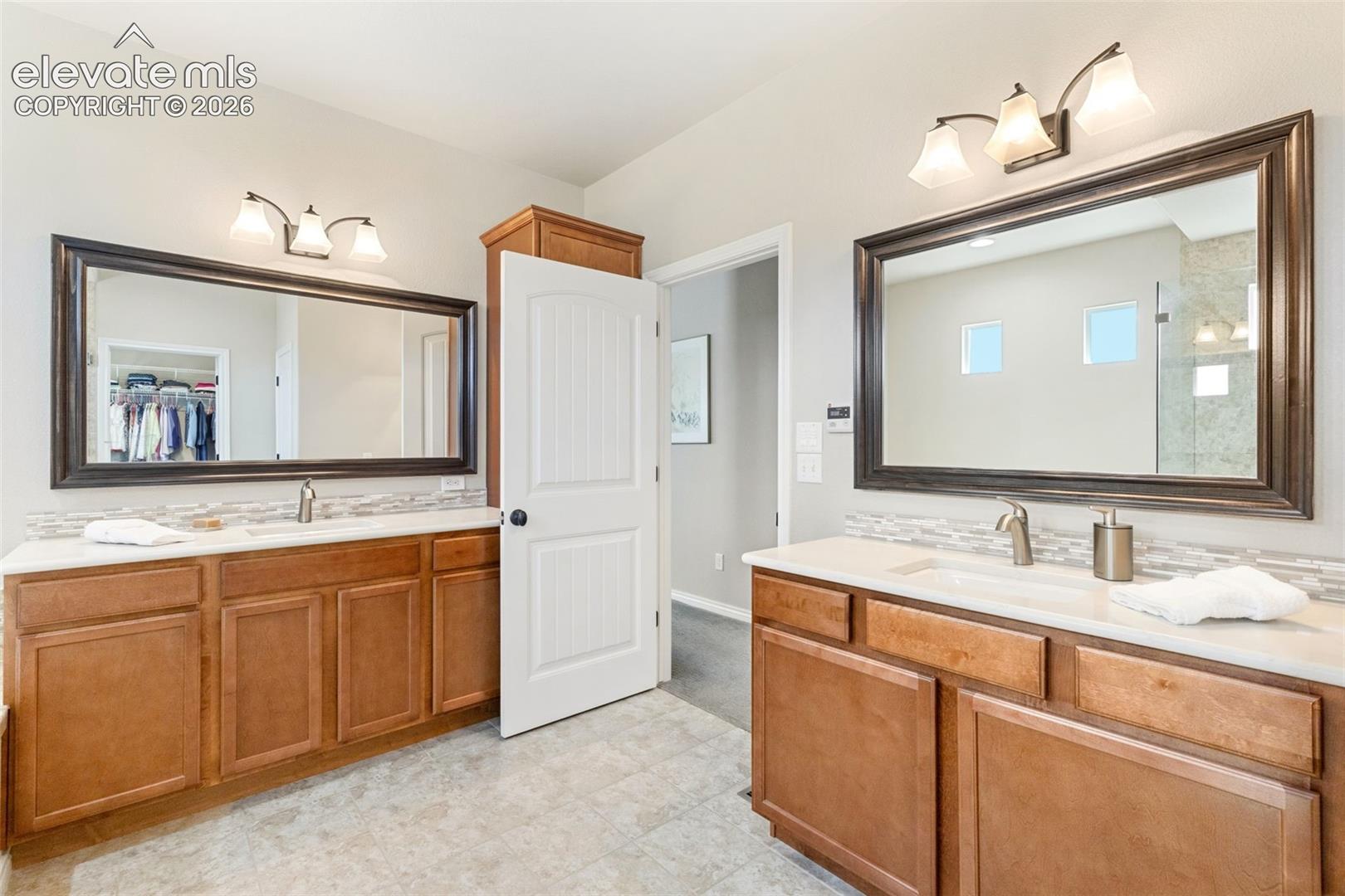 Dual vanities in primary bath featuring quartz countertops