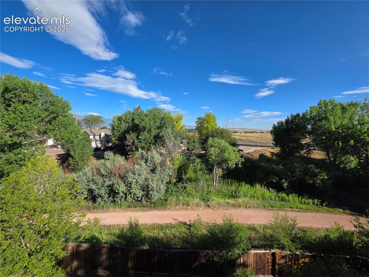 Seller Provided Photo of View of Tree Lined Walking Trail Behind Home