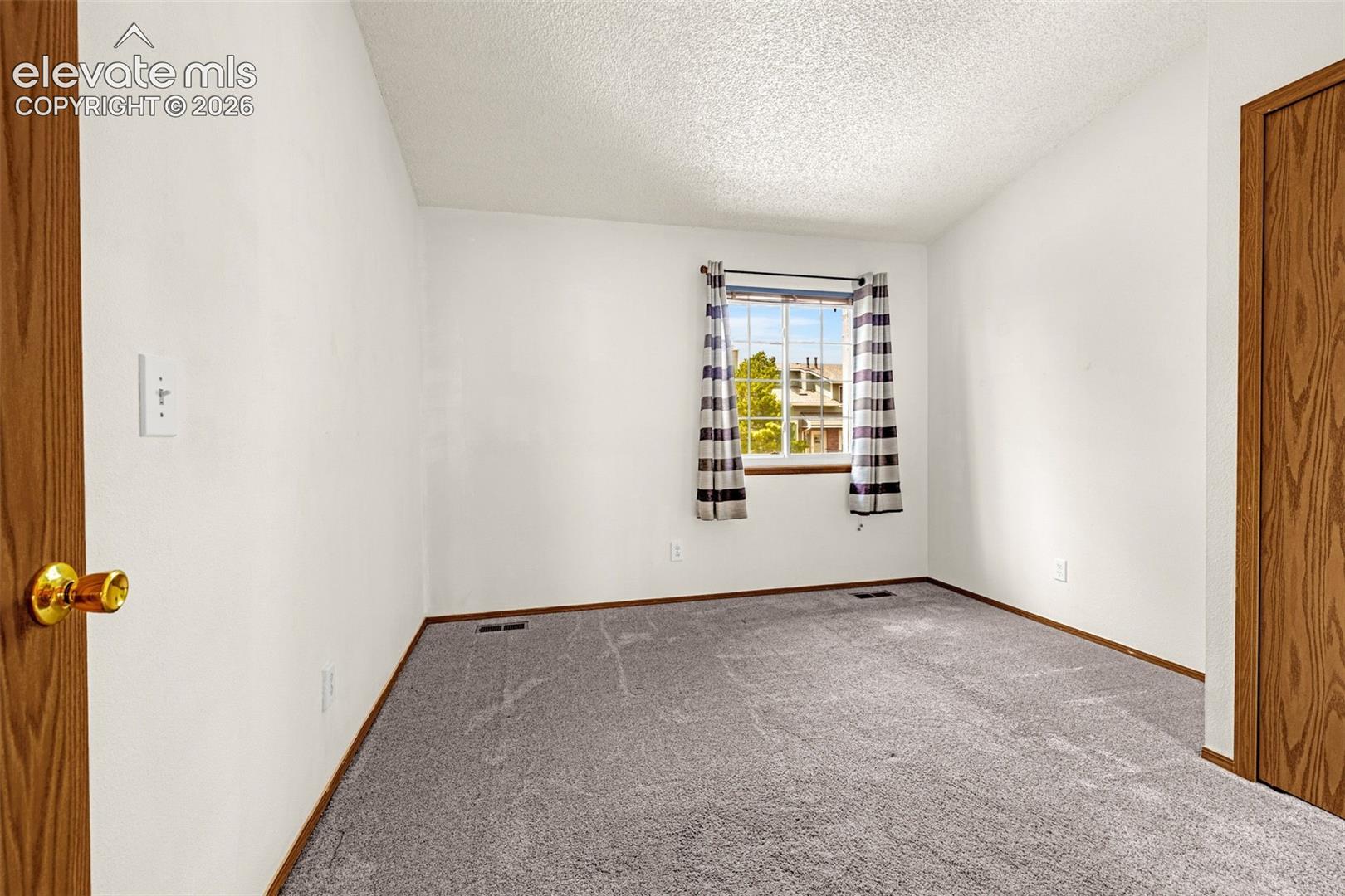 Neutral-toned walls complement the gray carpeting