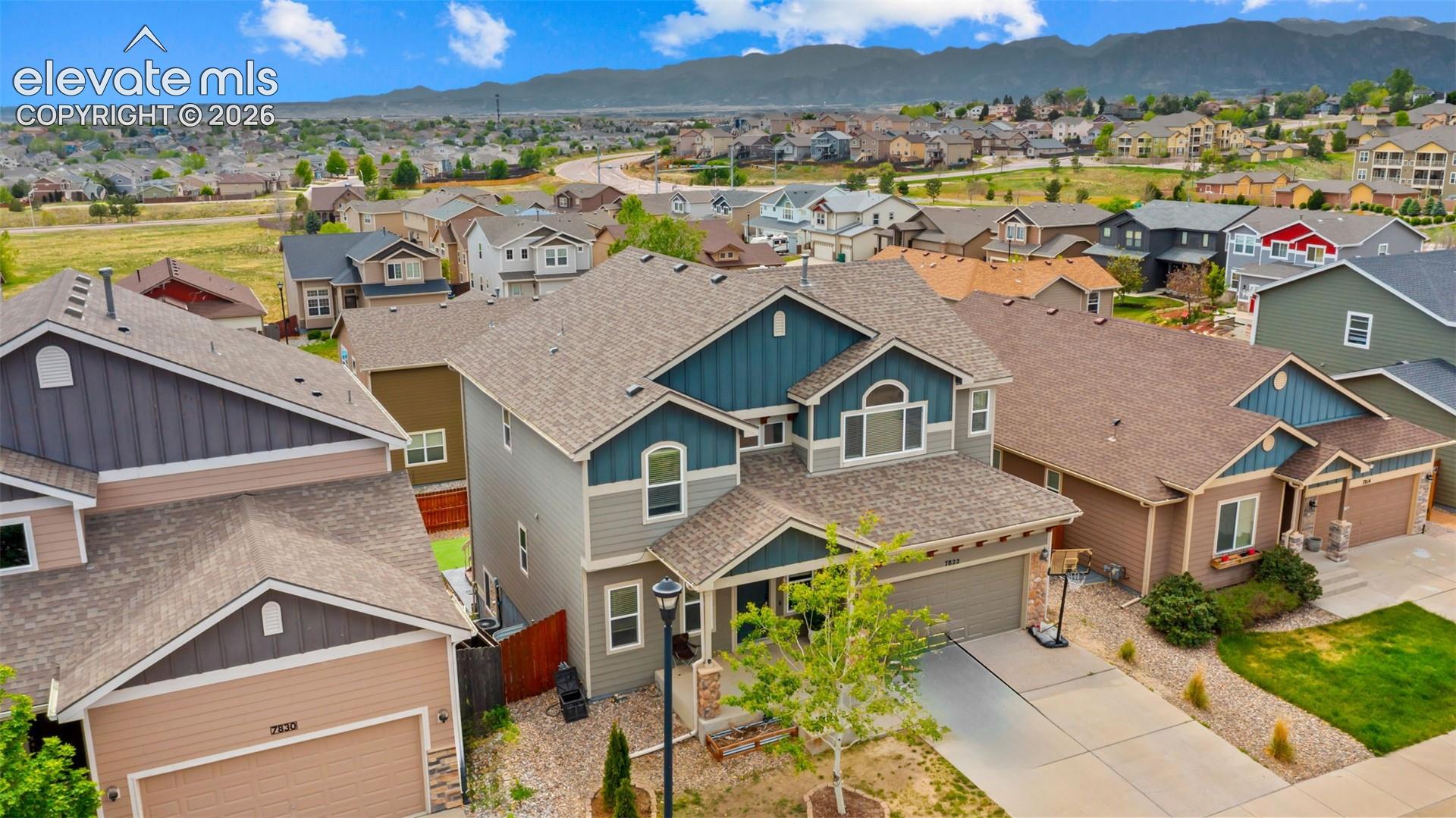 Multi-story residence featuring a three-car tandem garage, pitched roof, and mixed siding