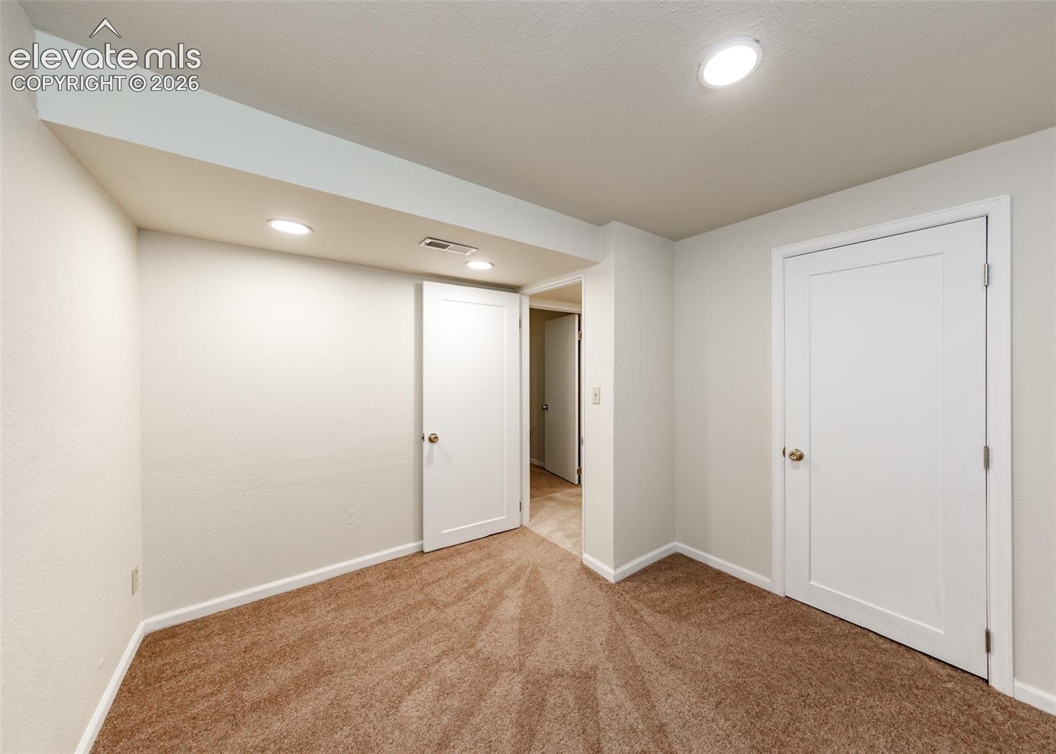 Neutral interior featuring wall-to-wall carpeting, recessed ceiling lighting, and solid-core interior doors with satin nickel hardware