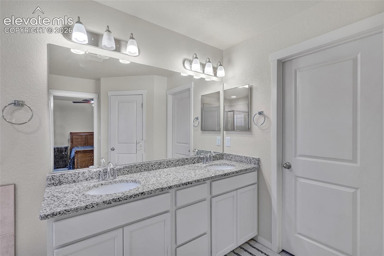 Dual vanity with light-toned countertop, integrated sinks, and chrome-finish faucets