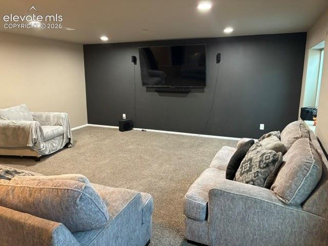 Finished room featuring neutral carpeting, a dark accent wall, and recessed lighting