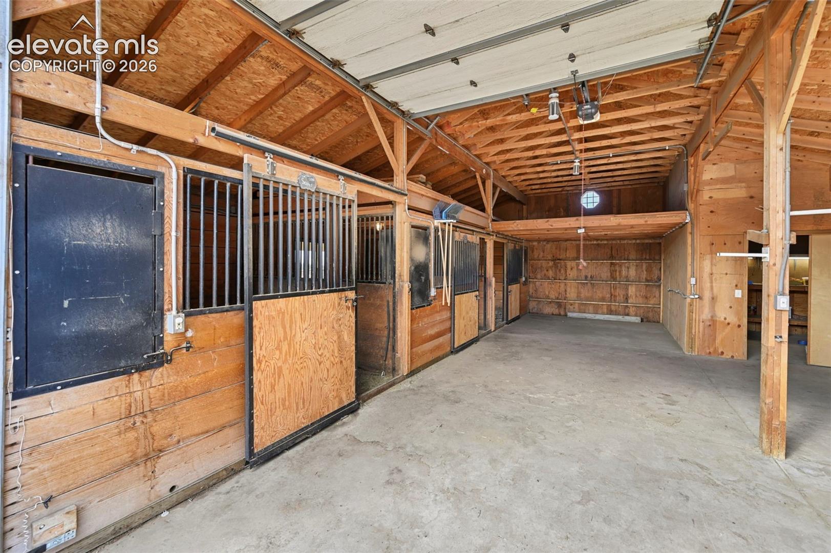 Barn interior featuring 2 garage doors, heated tack room.