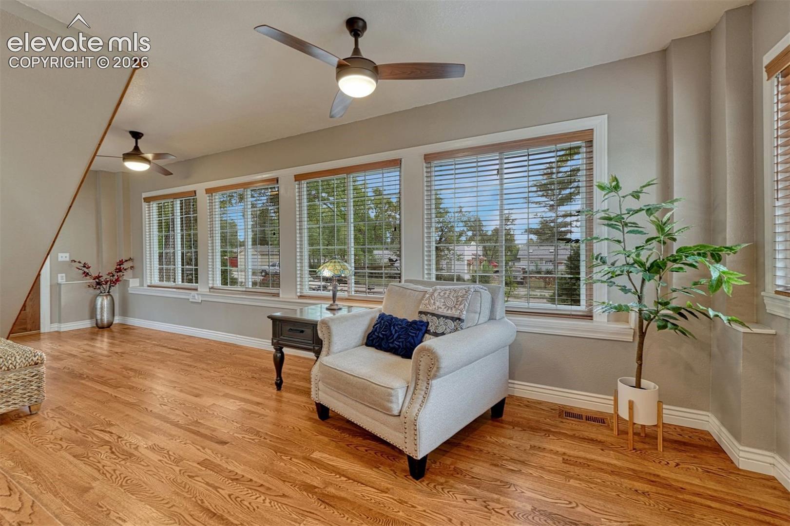 Additional living space with gorgeous hardwood floors and a wall of windows.