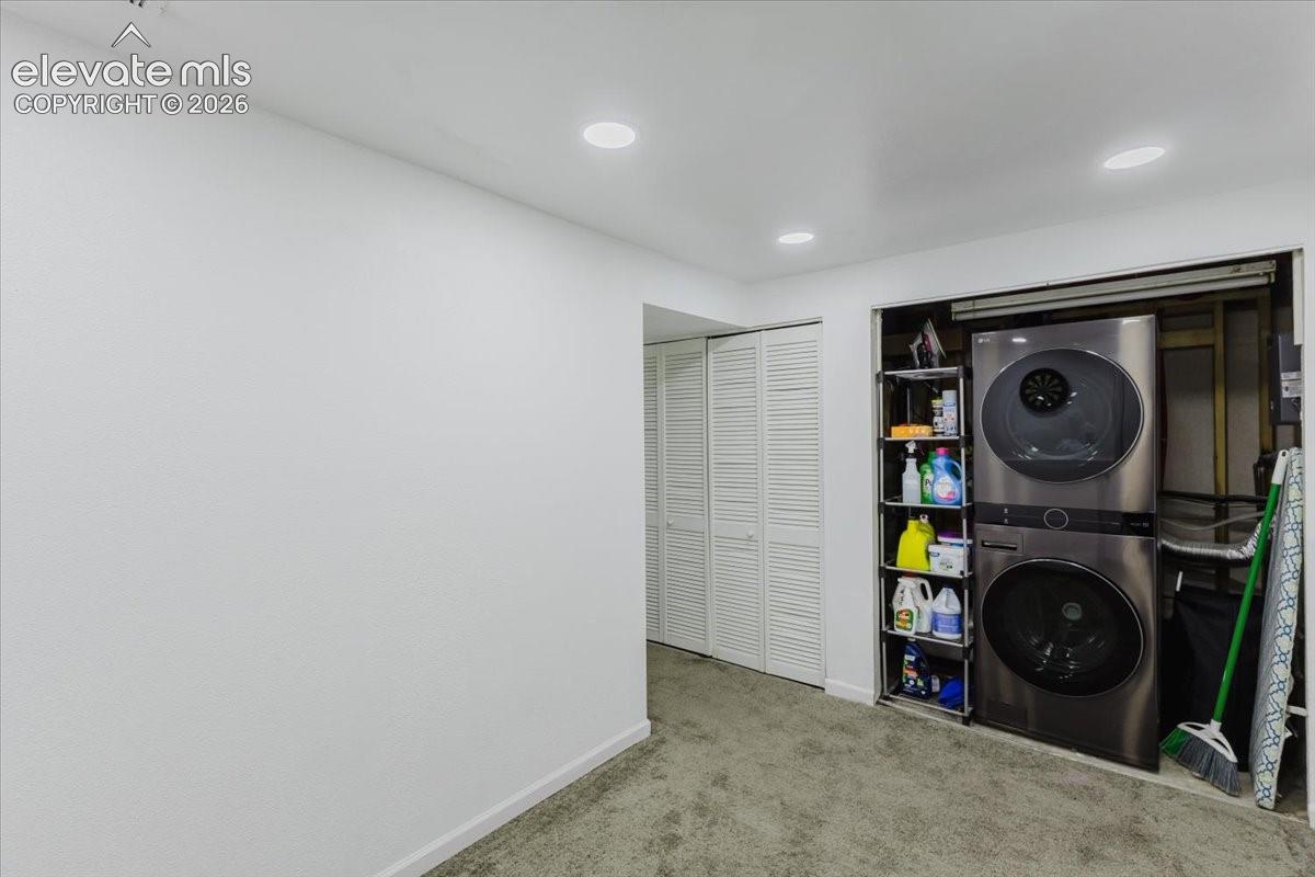 Dedicated laundry area featuring a stacked washer and dryer unit