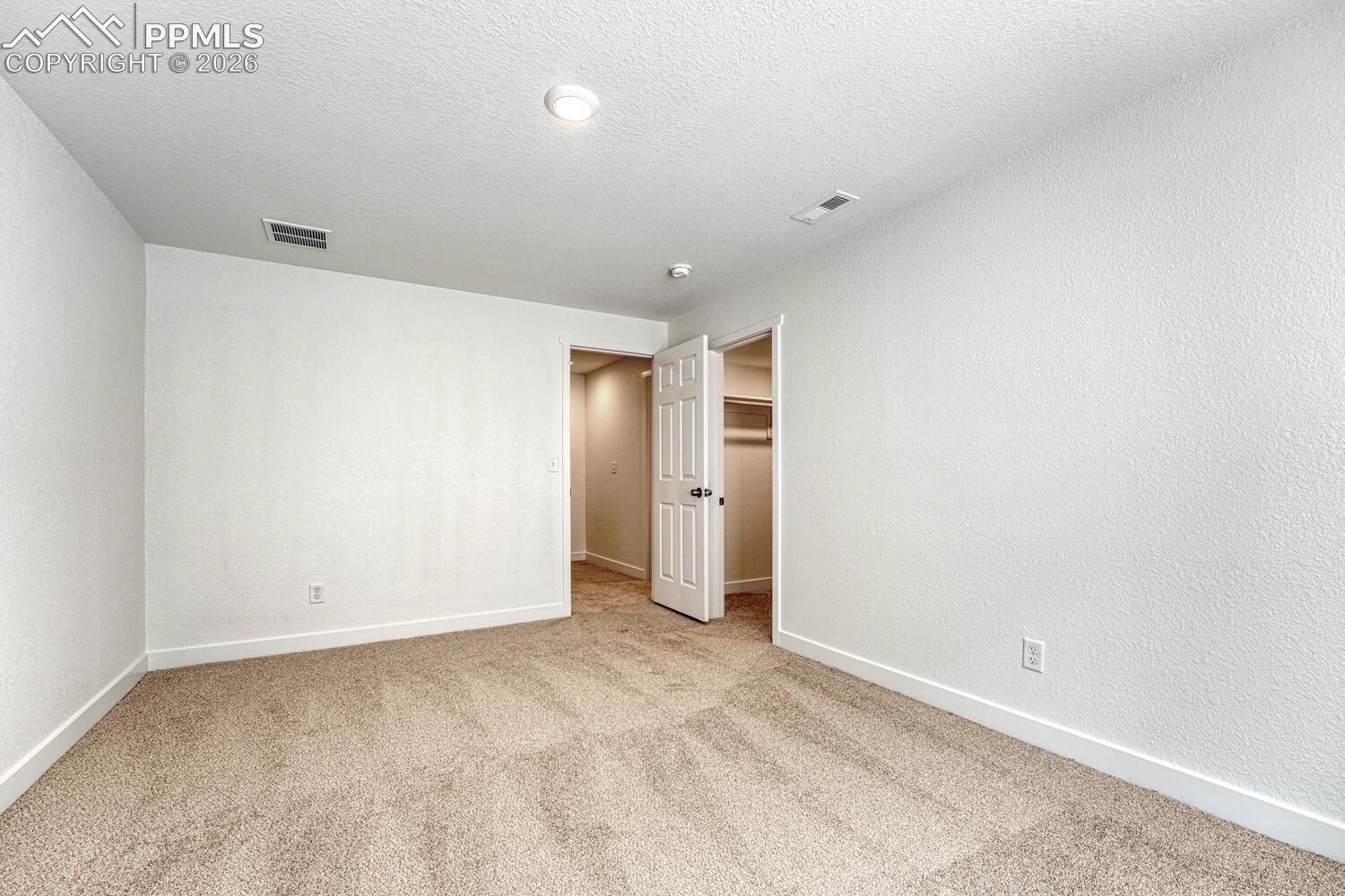 Walk-in closet for use as a wardrobe or extra storage.