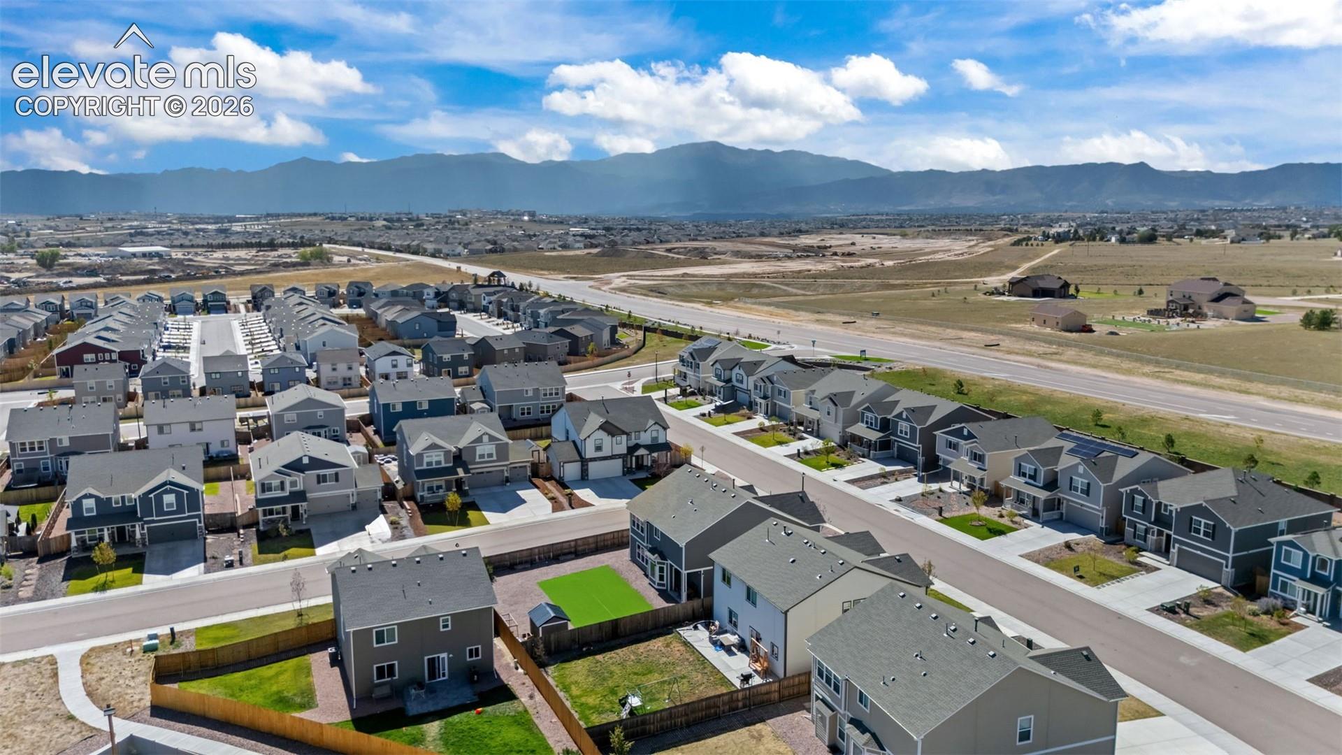 Residential community featuring a variety of home styles, paved streets, and mountain backdrop