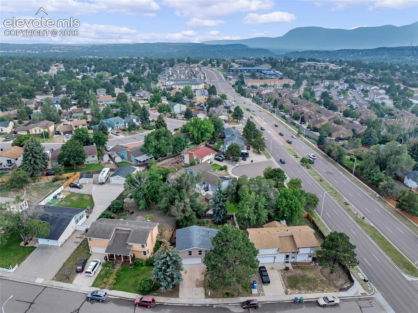 Residential area featuring mature trees and mountain scenery