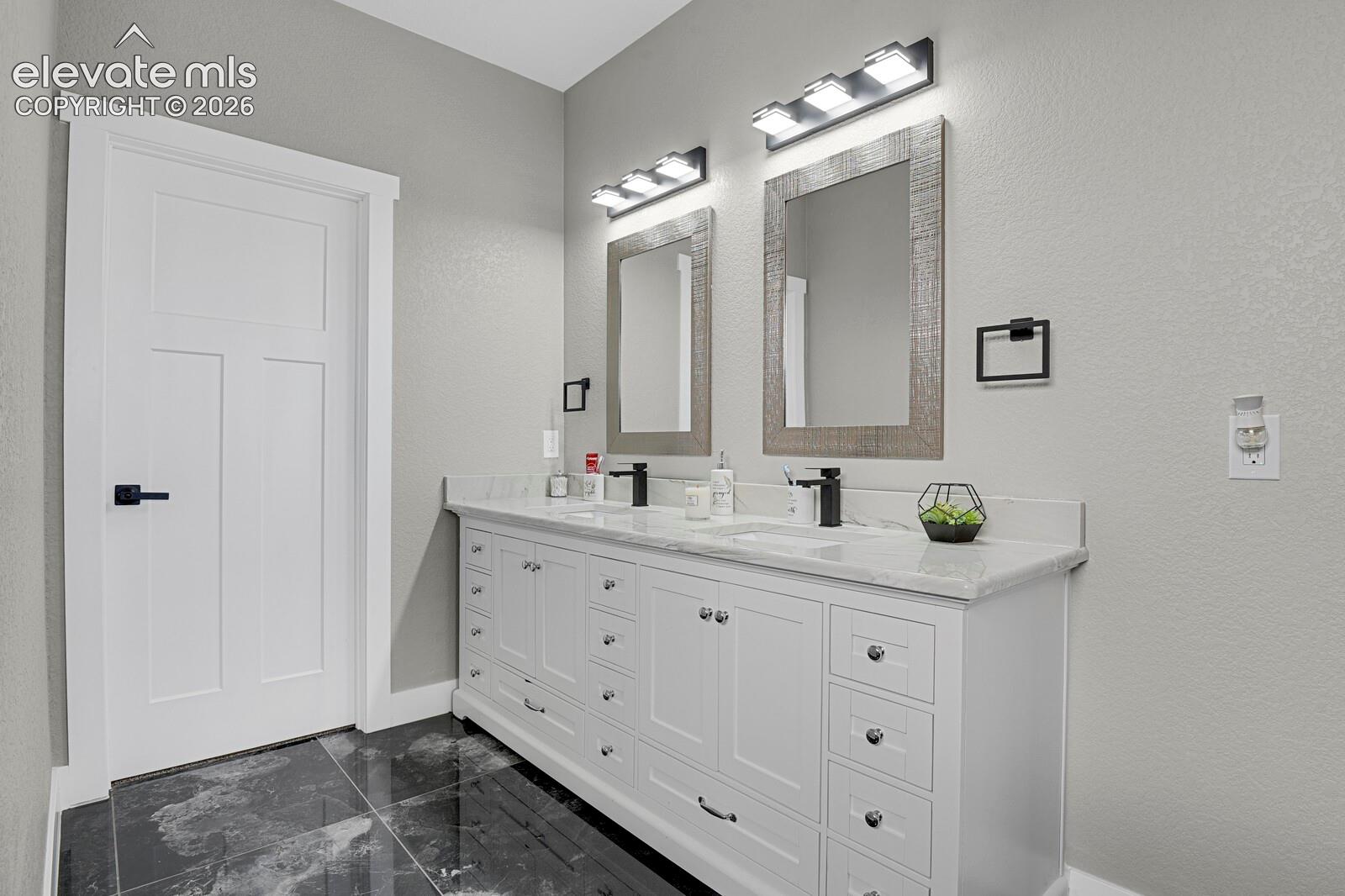 Double vanity with a light-toned countertop, two integrated sinks, and individual mirrors with rustic-finish frames