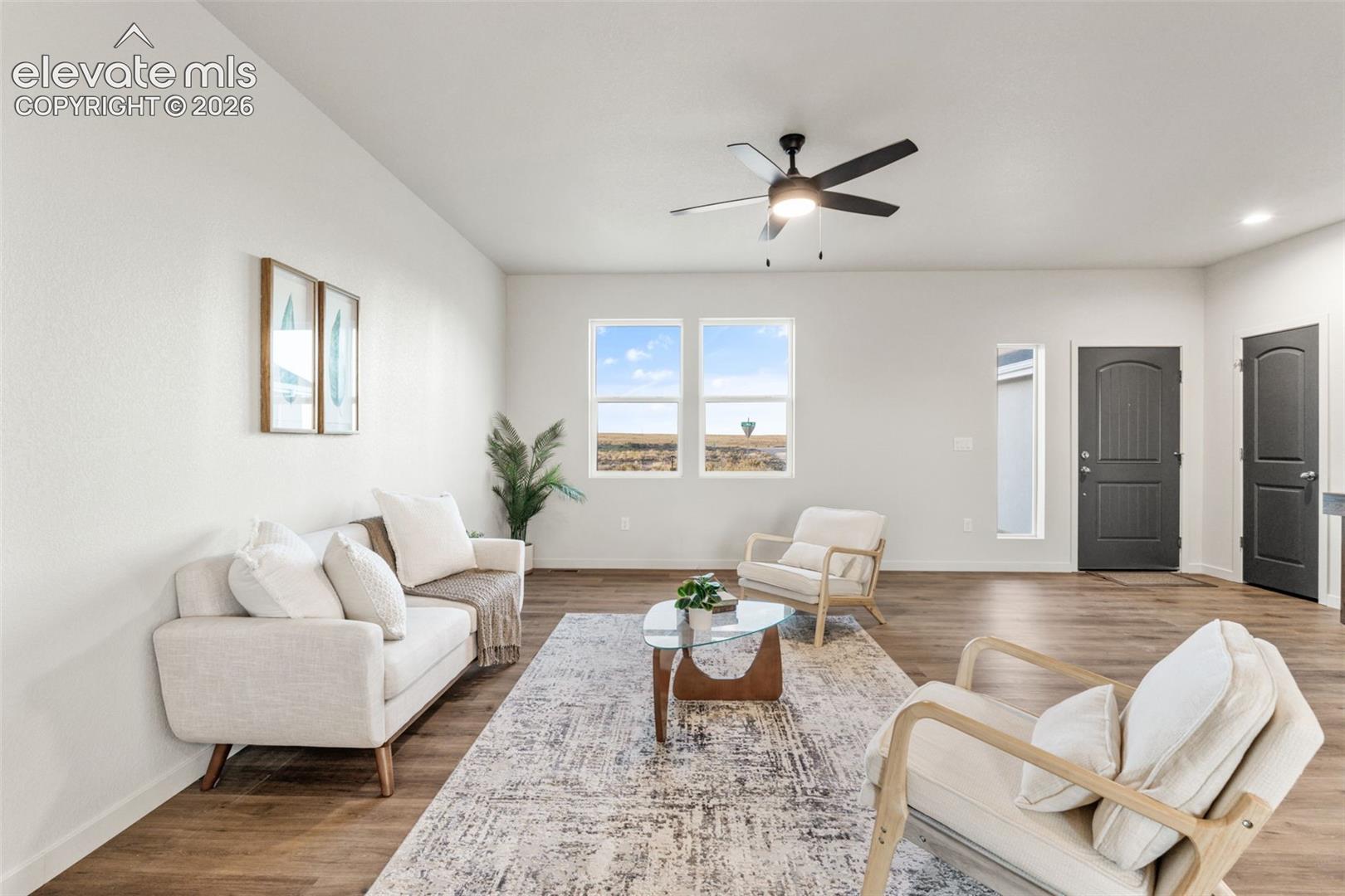 Open-concept room featuring wood-finish flooring, dual-pane windows, recessed lighting, and a ceiling fan with integrated light fixture