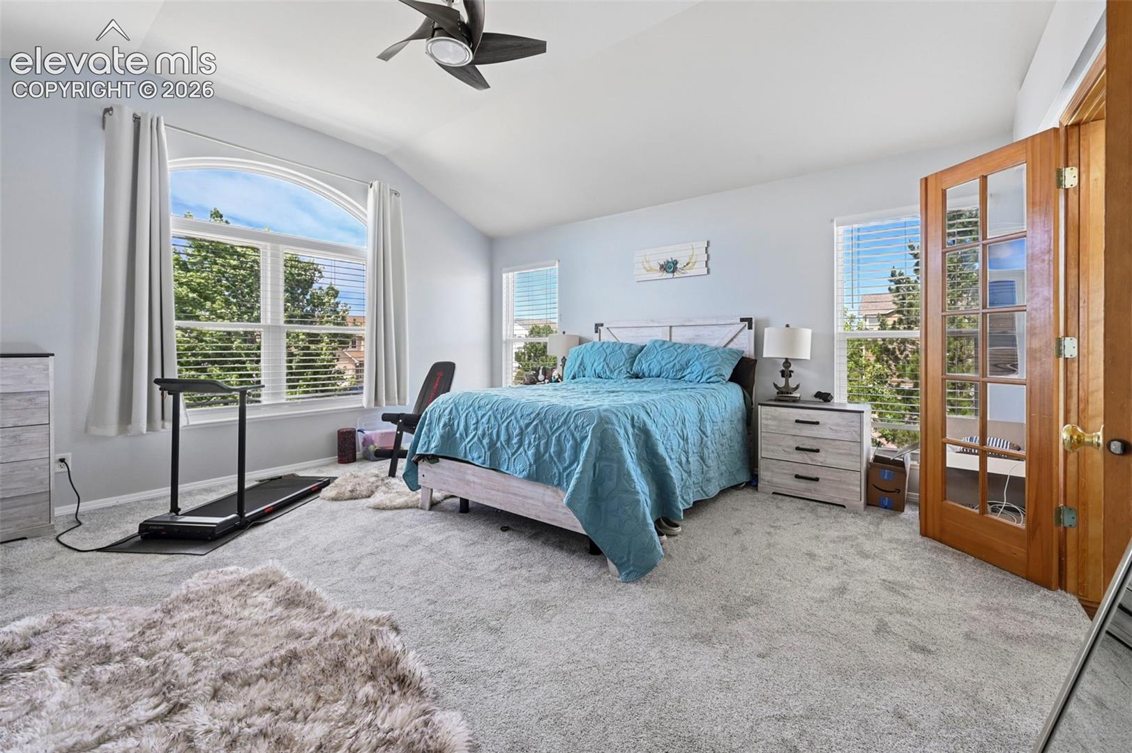 Spacious interior featuring vaulted ceilings and light grey carpeting