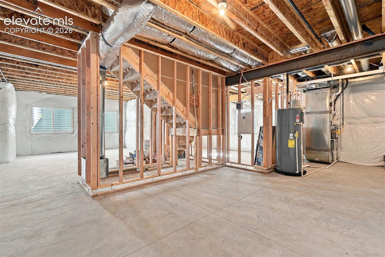 Unfinished basement with exposed ceiling joists, and concrete flooring
