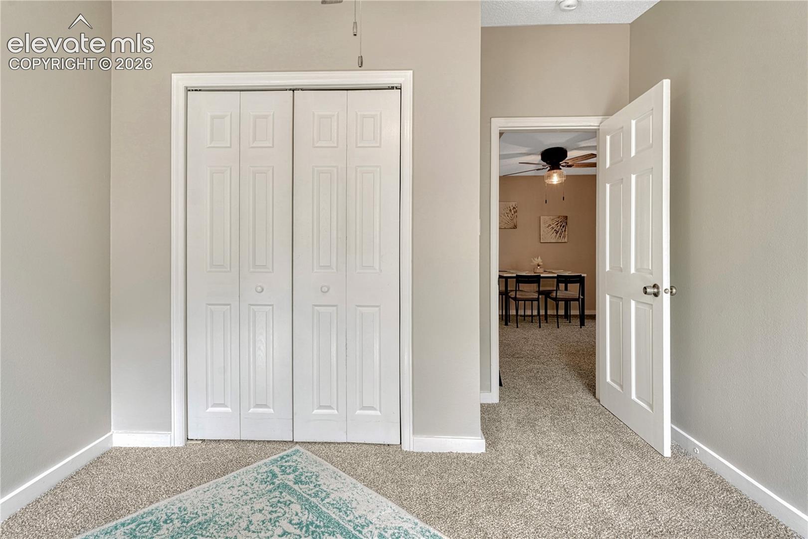 Textured carpeting, white bi-fold closet doors, and light-toned walls