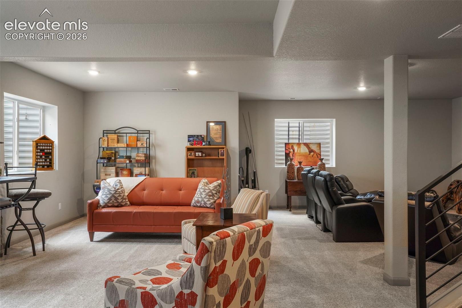 Spacious lower-level area featuring recessed lighting, light gray carpeting, and painted walls