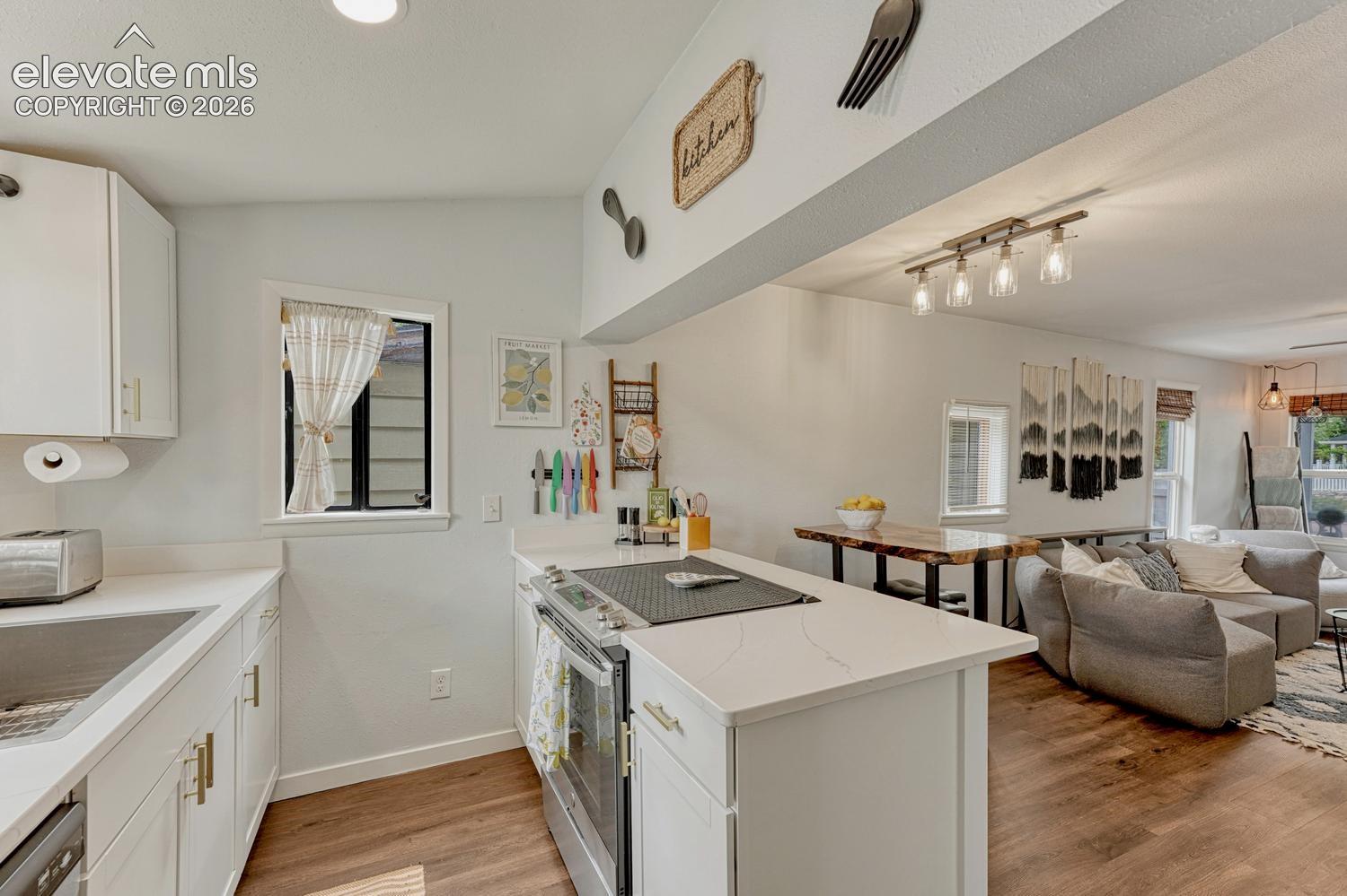 Modern kitchen featuring white cabinetry, quartz countertops, and stainless steel appliances