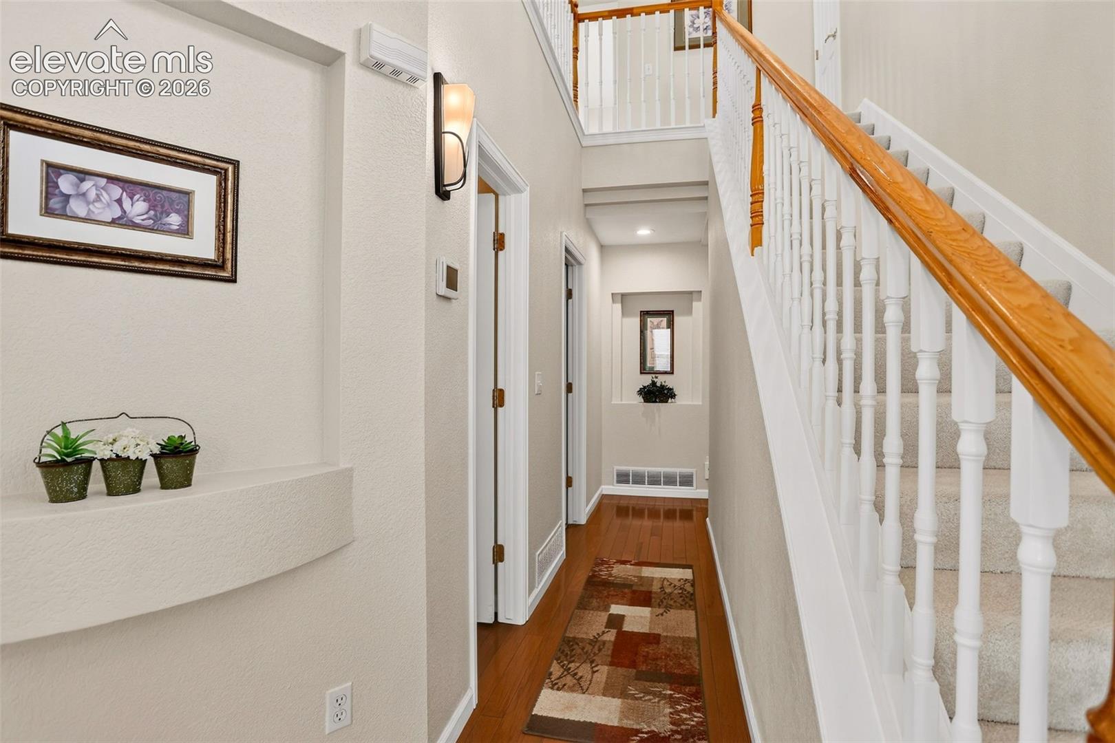 Staircase with light wood-finish handrail and white balusters