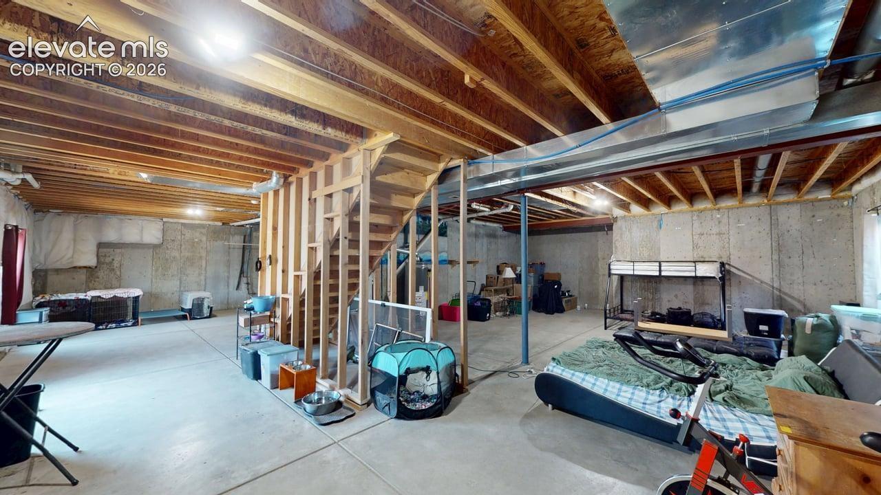 Unfinished basement featuring exposed wood joists and concrete flooring