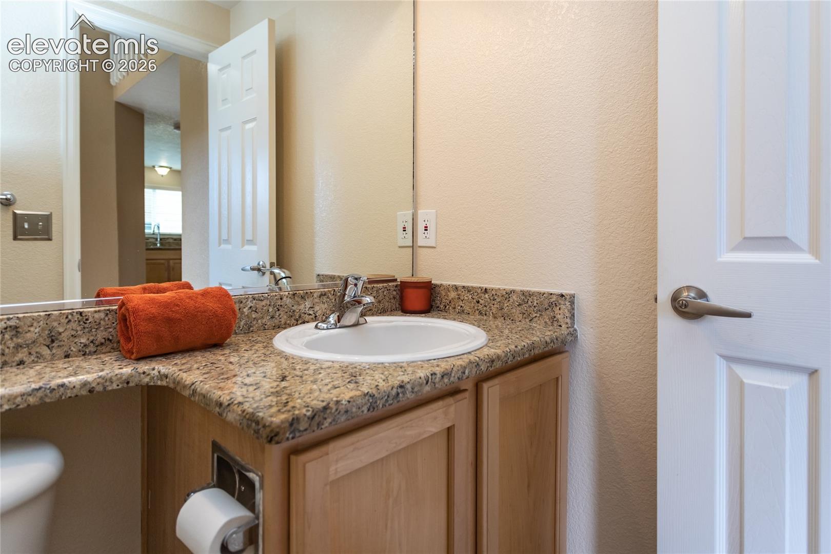 1/2 bathroom on main level with a granite countertop