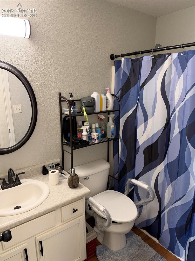 Vanity featuring a solid surface countertop with an integrated oval sink, matte black faucet, and white cabinetry