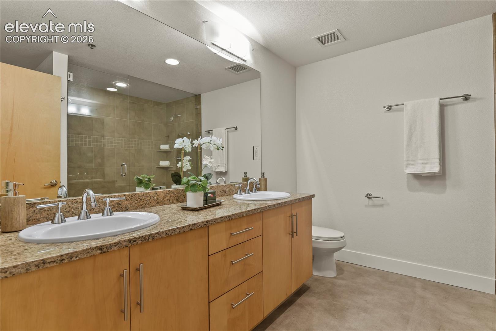 Primary bathroom with 8' vanity, stone counters and designer lighting
