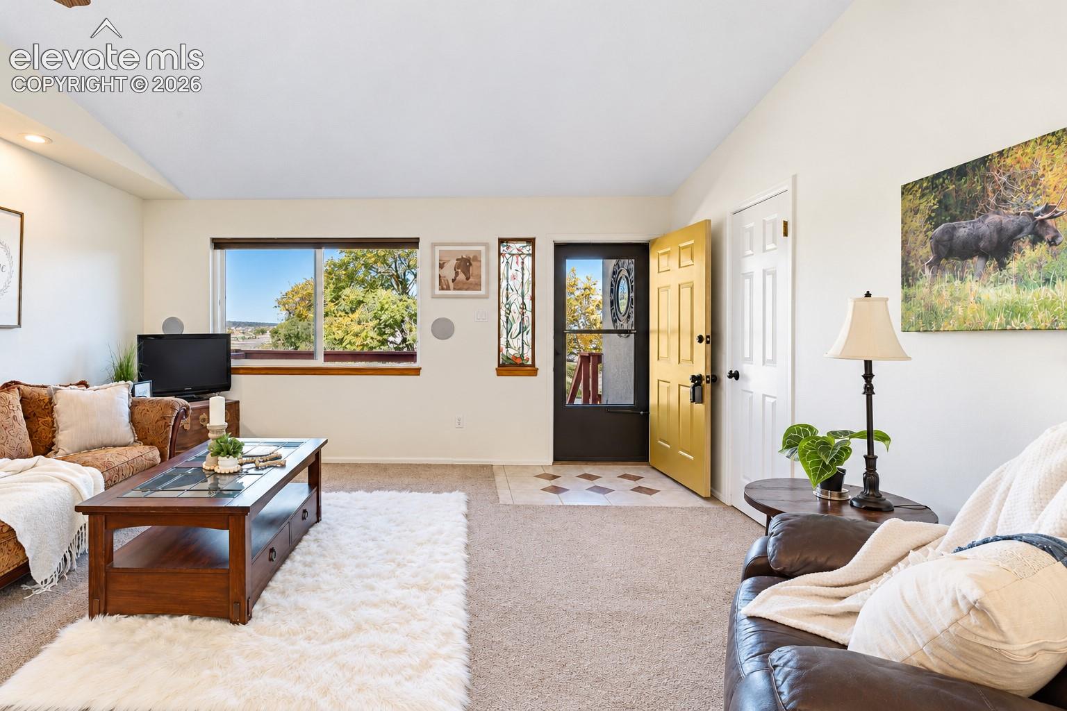 Vaulted ceilings, large windows with natural light, tiled entryway, and decorative vertical sidelight window