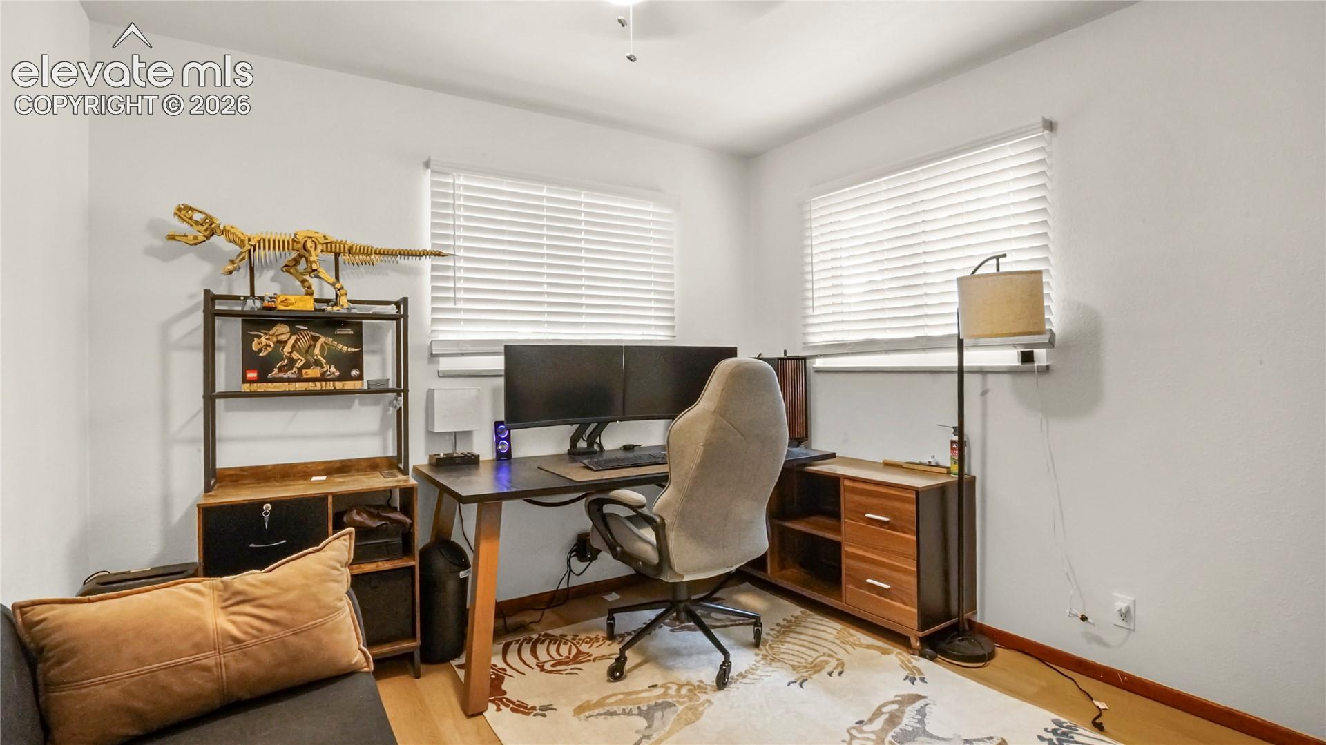 Main floor bedroom or office, LVP flooring, and white window blinds