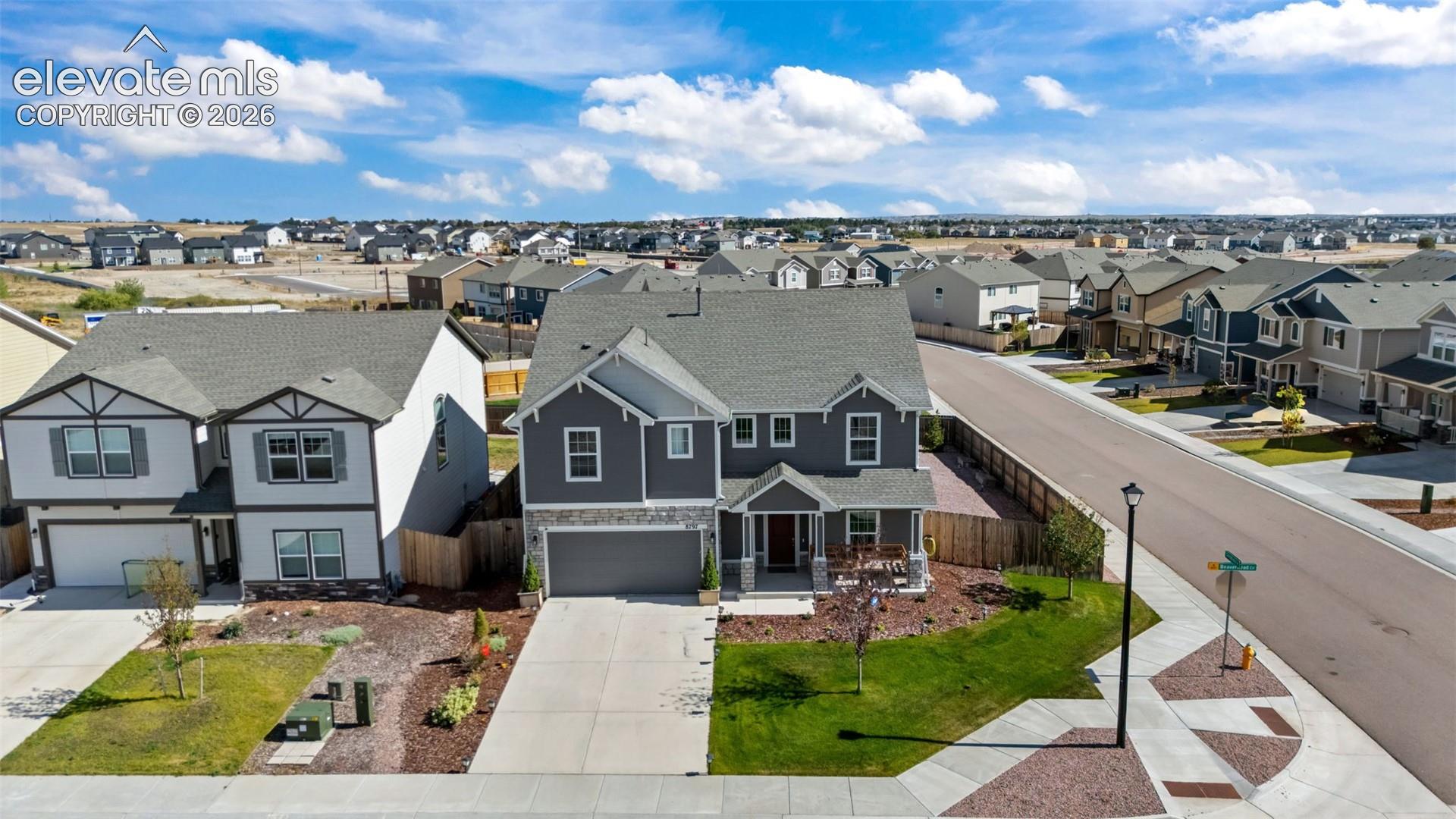 Contemporary two-story residence with a covered front porch, an attached two-car garage, and a landscaped front yard