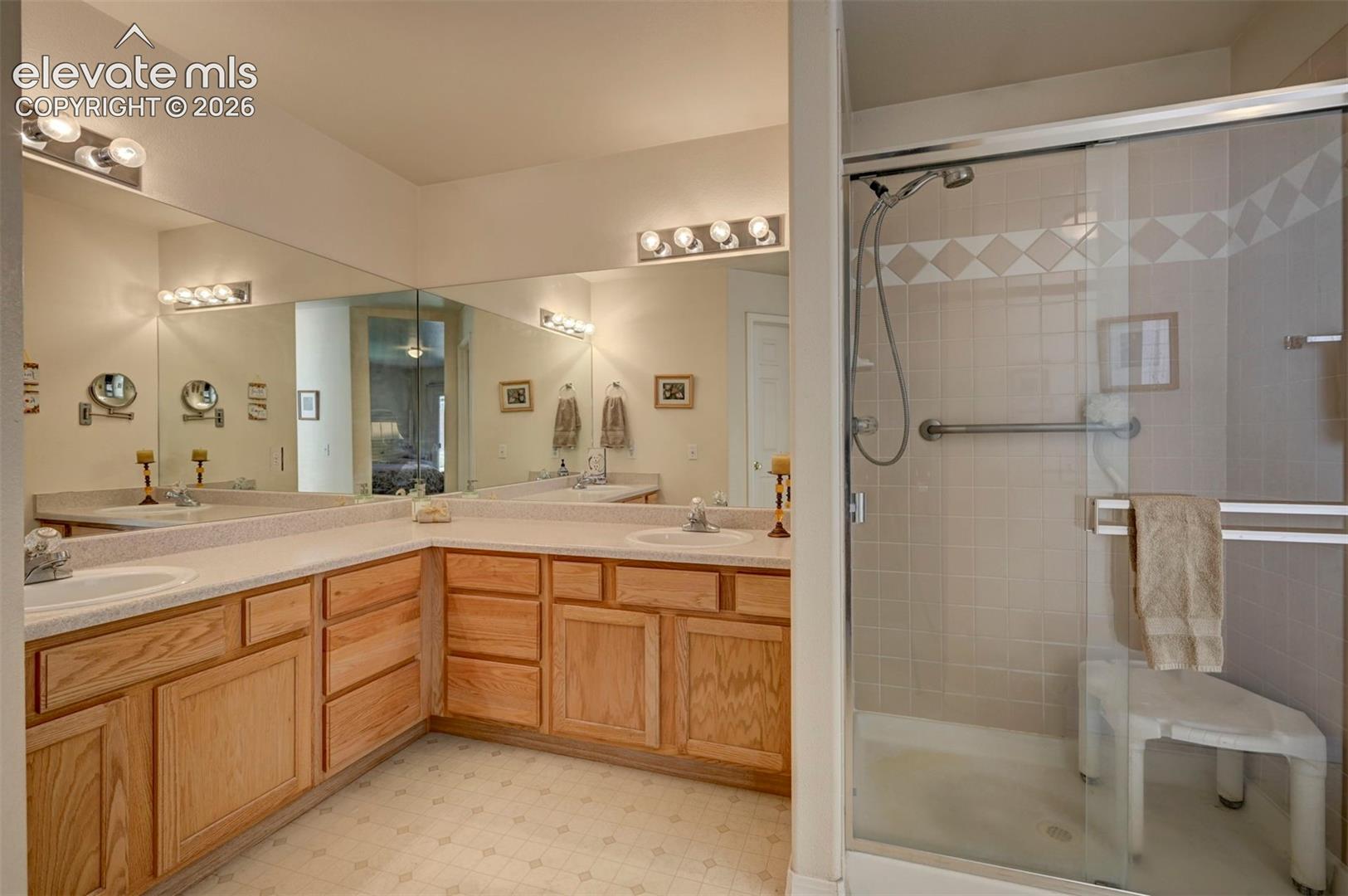 Primary Bathroom with dual vanity and shower view.