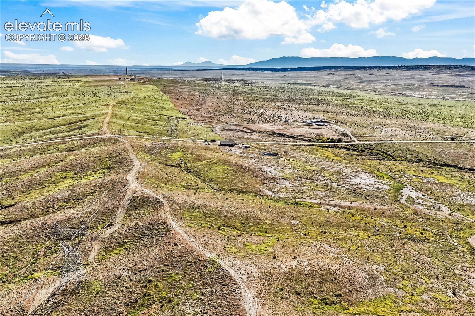 Expansive acreage featuring rugged desert topography, native vegetation, natural rolling terrain, and distant mountain silhouettes