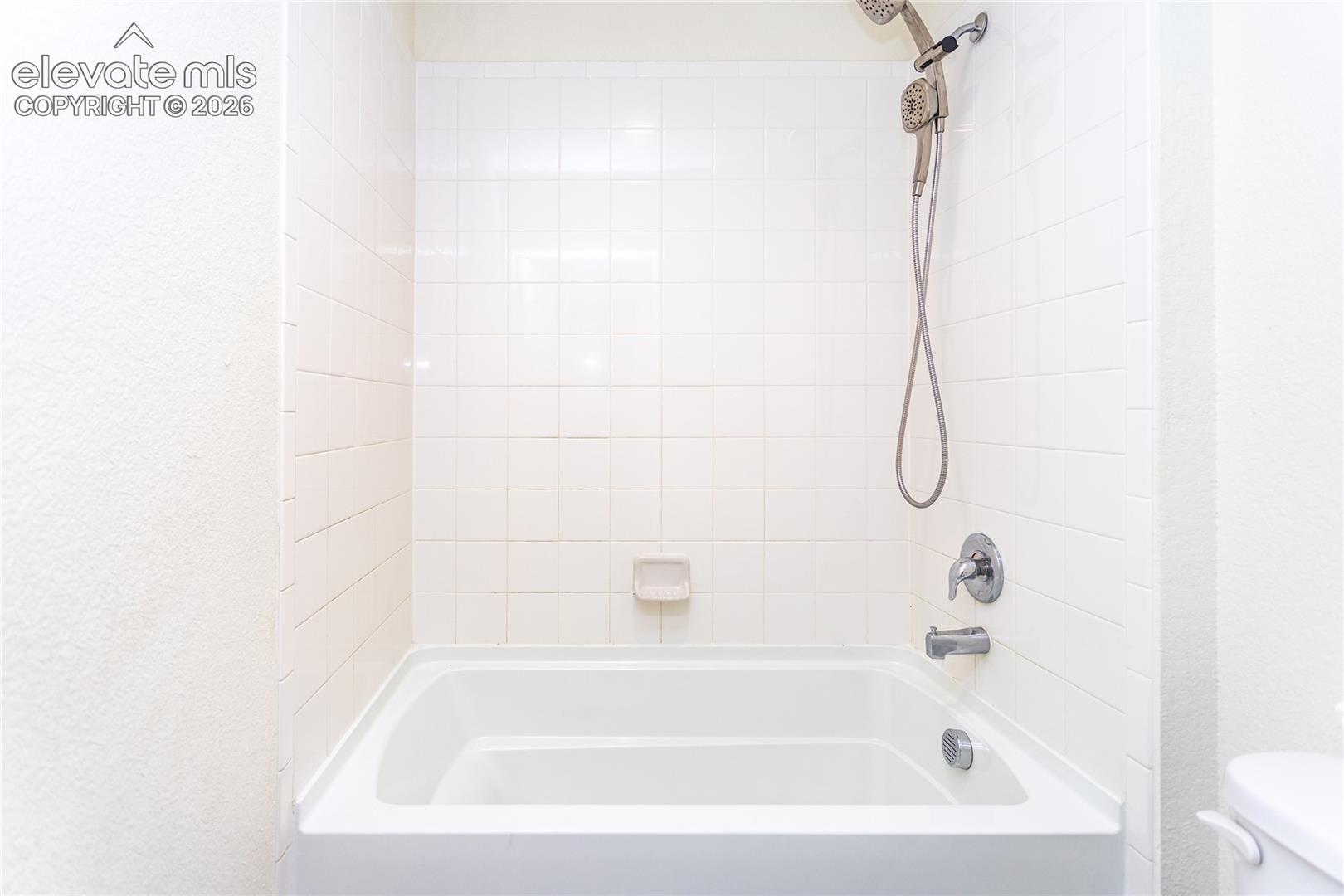 Upper hall bathroom has a large tub with tile surround that is conveniently separated by a door.