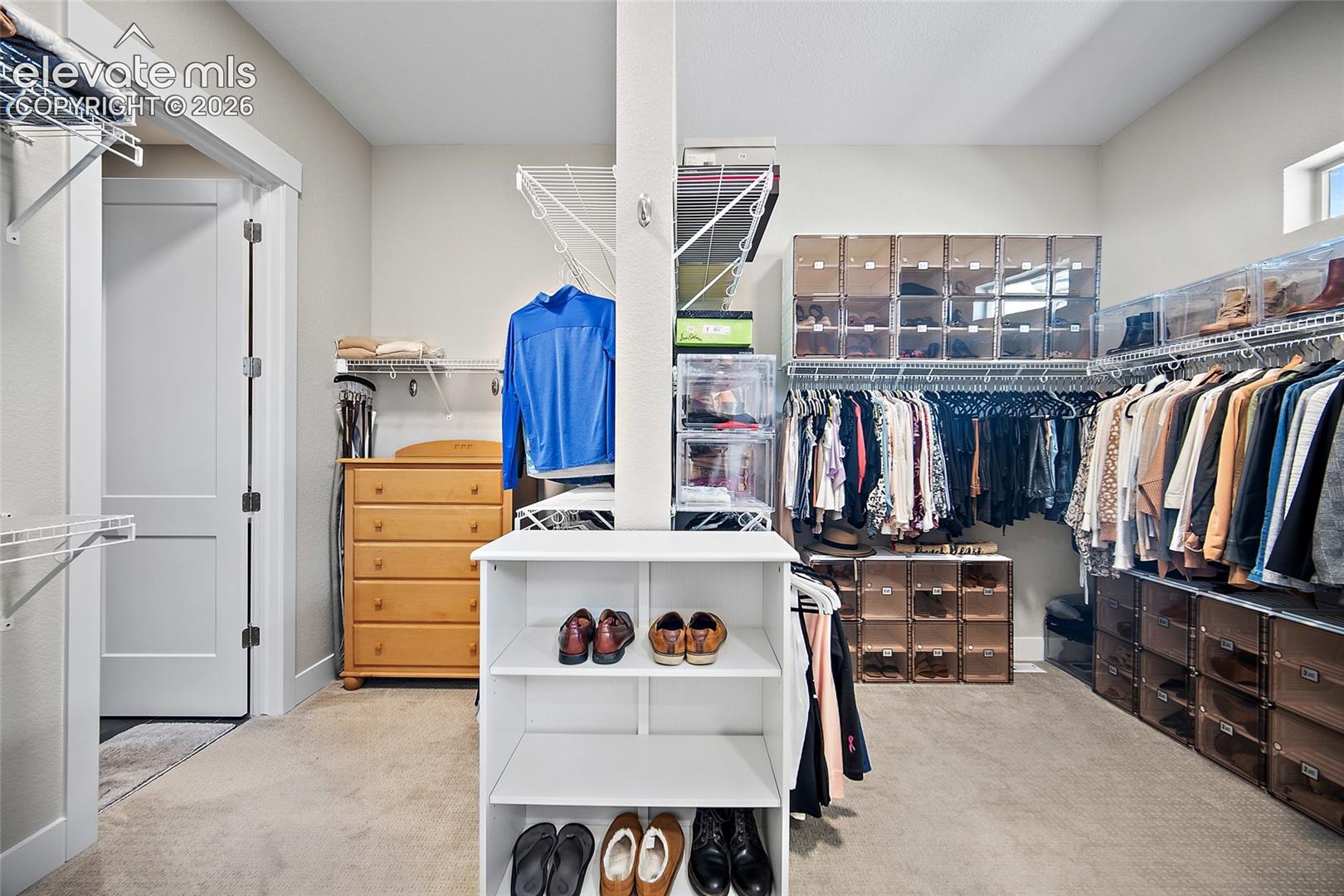 generous primary closet with direct access to custom laundry room