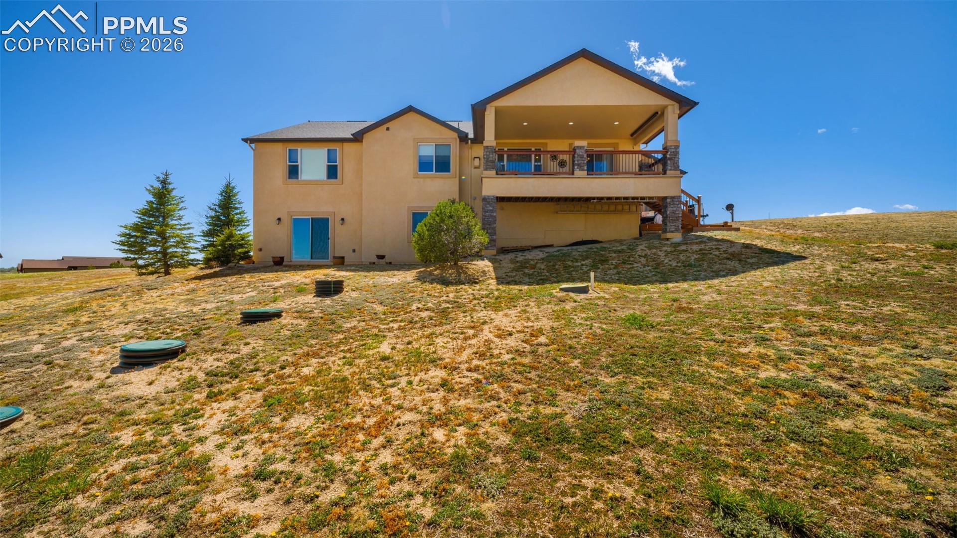 Rear view of property with stucco siding covered deck and recessed lighting