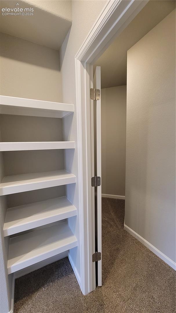 Shelving at the bottom of the stairs and a finished storage closet, located in the basement! 