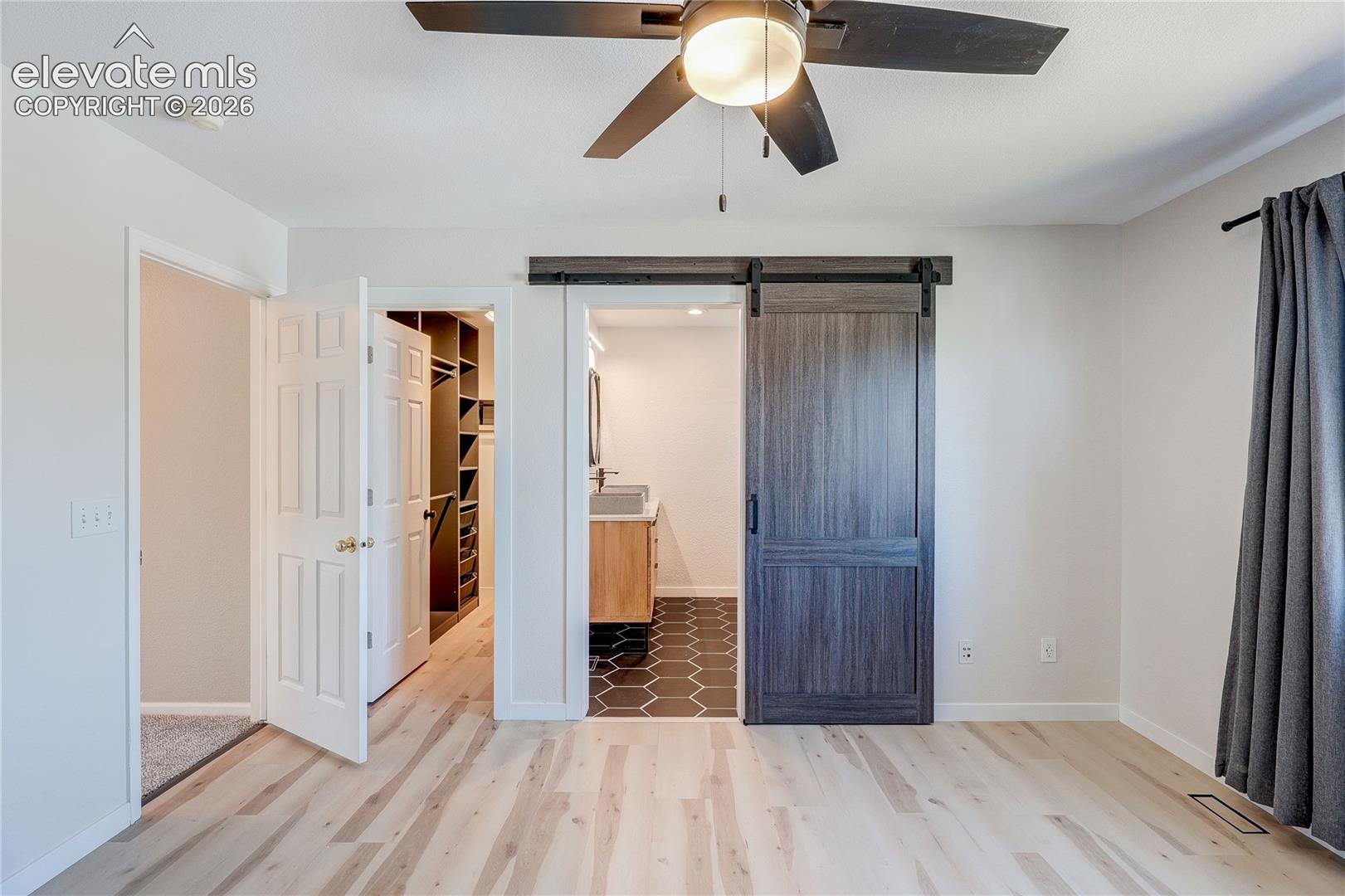 Walk-in closet and remodeled private bath with barn door. 
