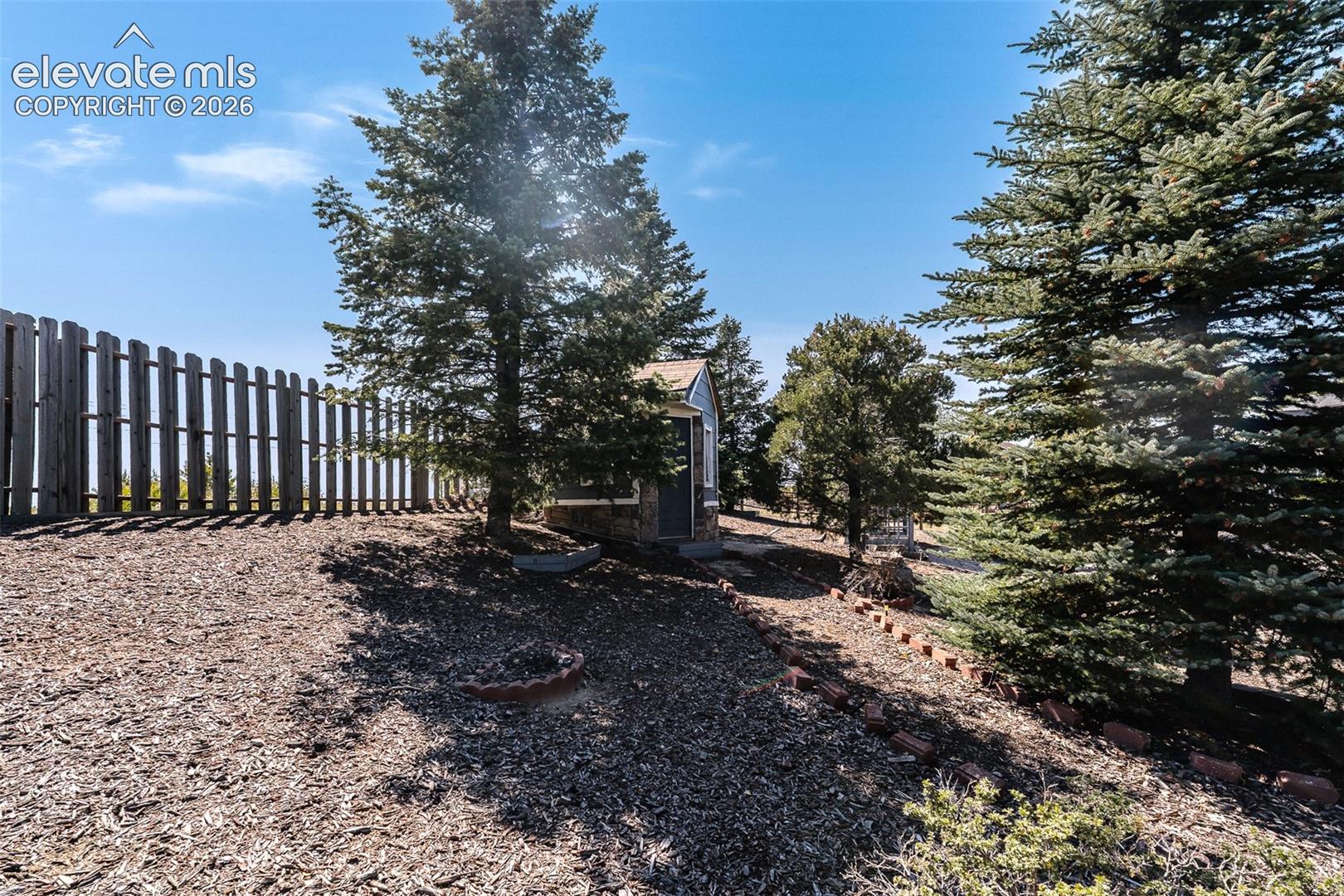 Fenced yard with mature trees for privacy.