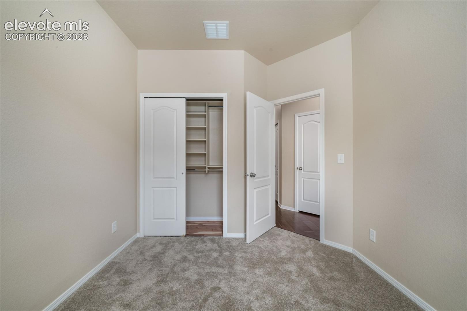 Neutral wall finishes, recessed ceiling light, paneled interior doors, and grey carpet flooring