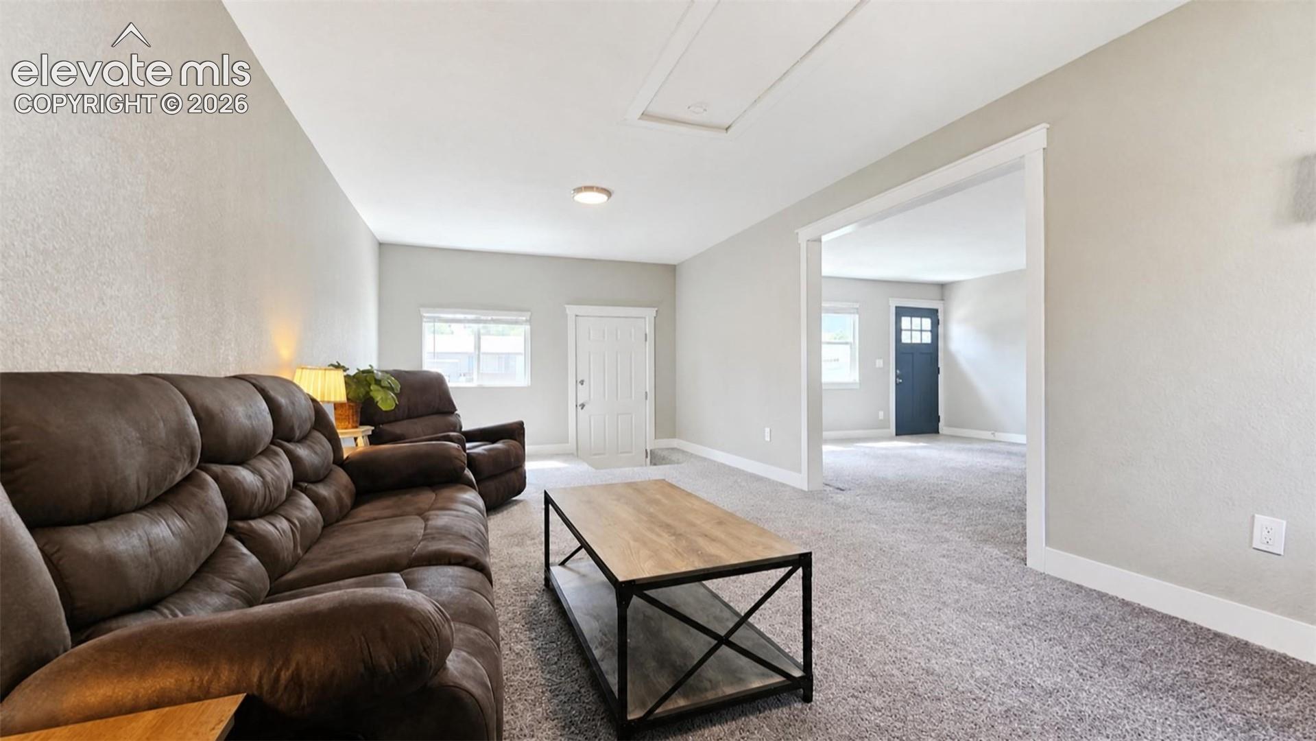 Carpeted living area with light-colored walls and white trim