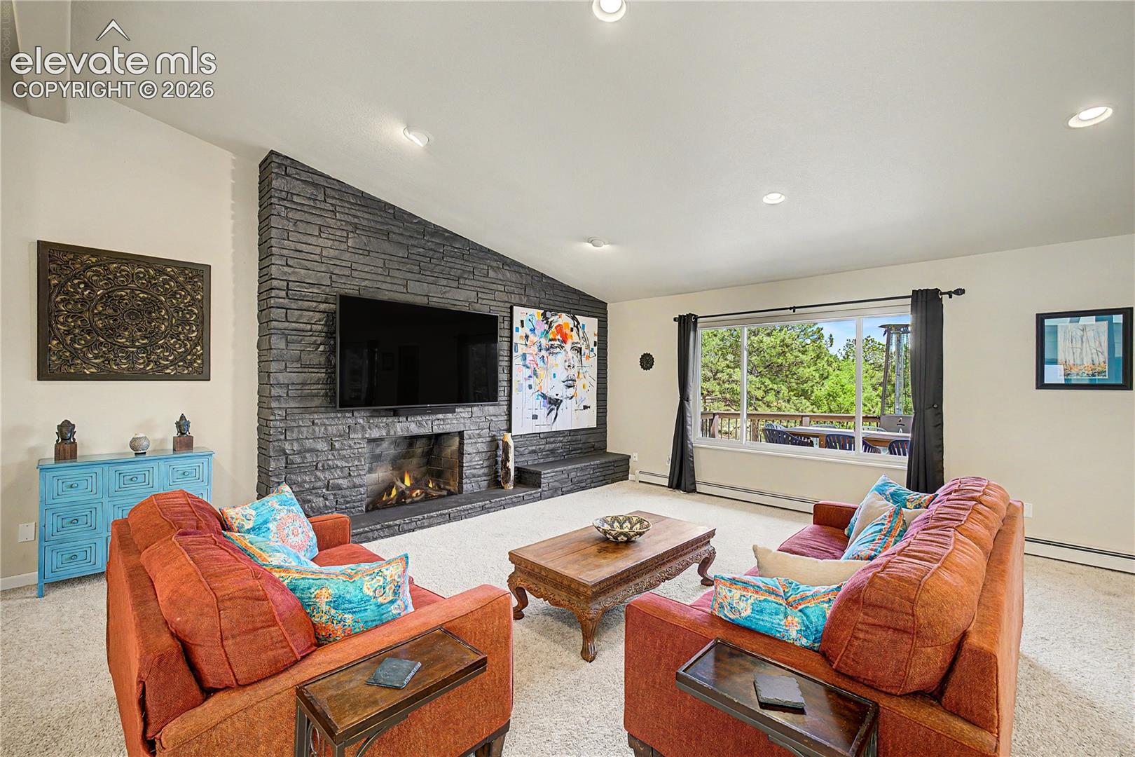 Pulling back reveals the full scale of the great room, where the stacked-stone fireplace and soaring ceilings create an inviting gathering space built for entertaining.