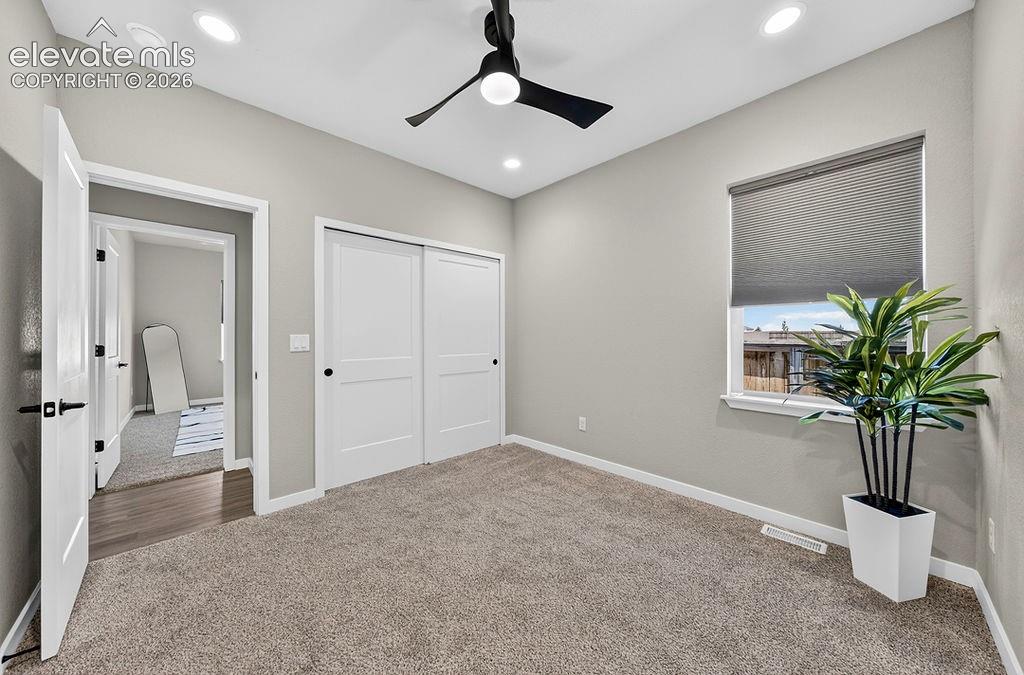 Light gray wall paint complemented by white trim and a white two-panel sliding closet door