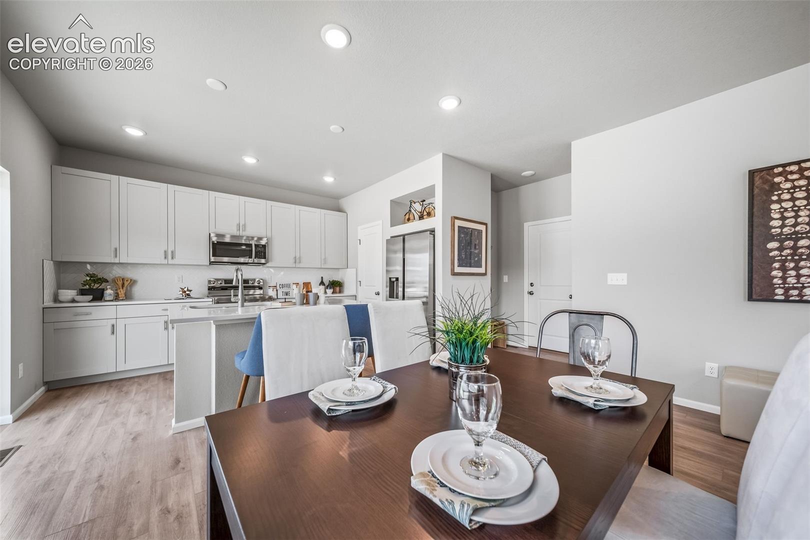 Open-concept living space with wood-finish flooring, recessed lighting, and light gray walls
*photos of a model home*