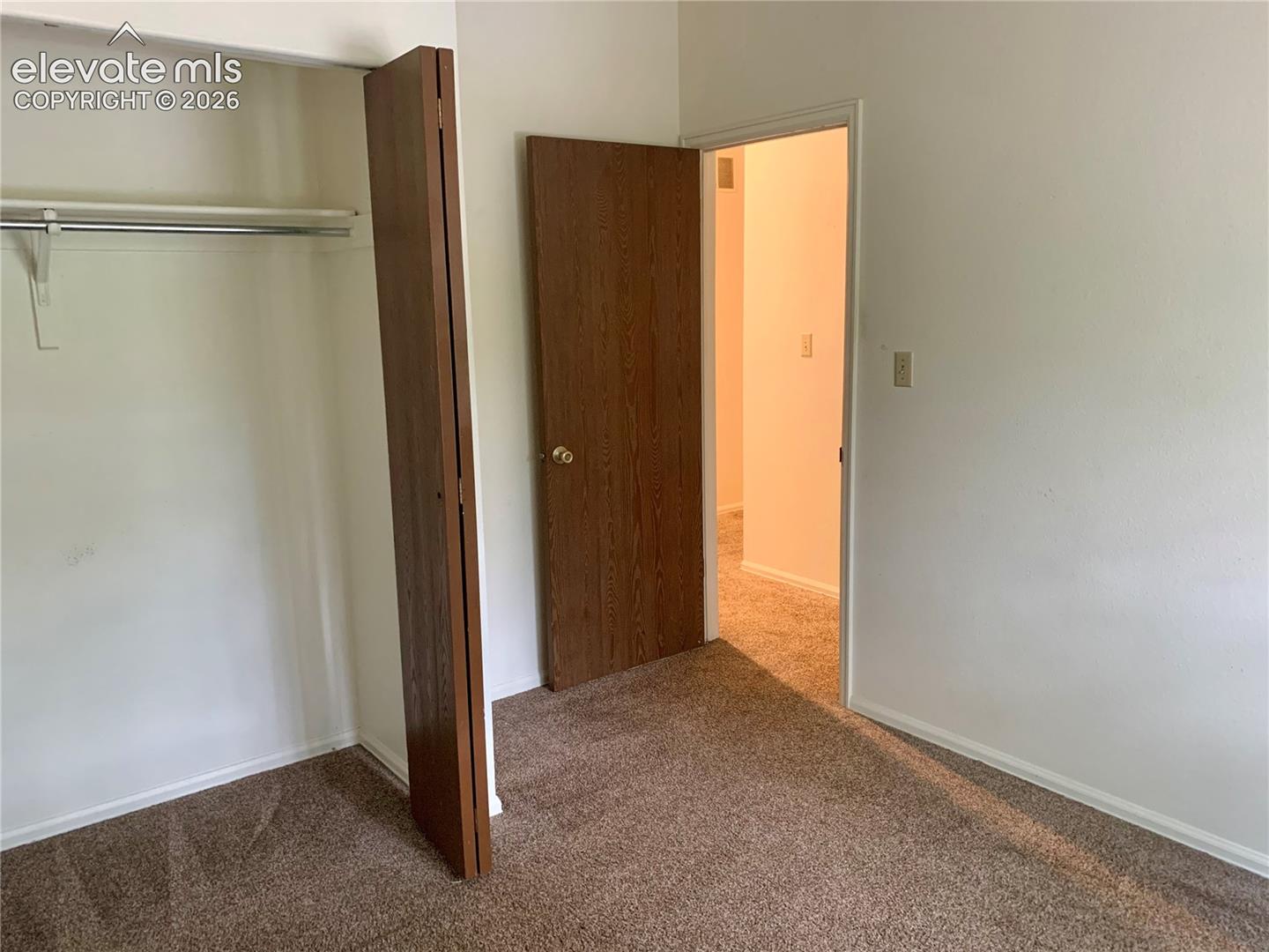 Wall-to-wall carpeting with light-colored walls and white trim