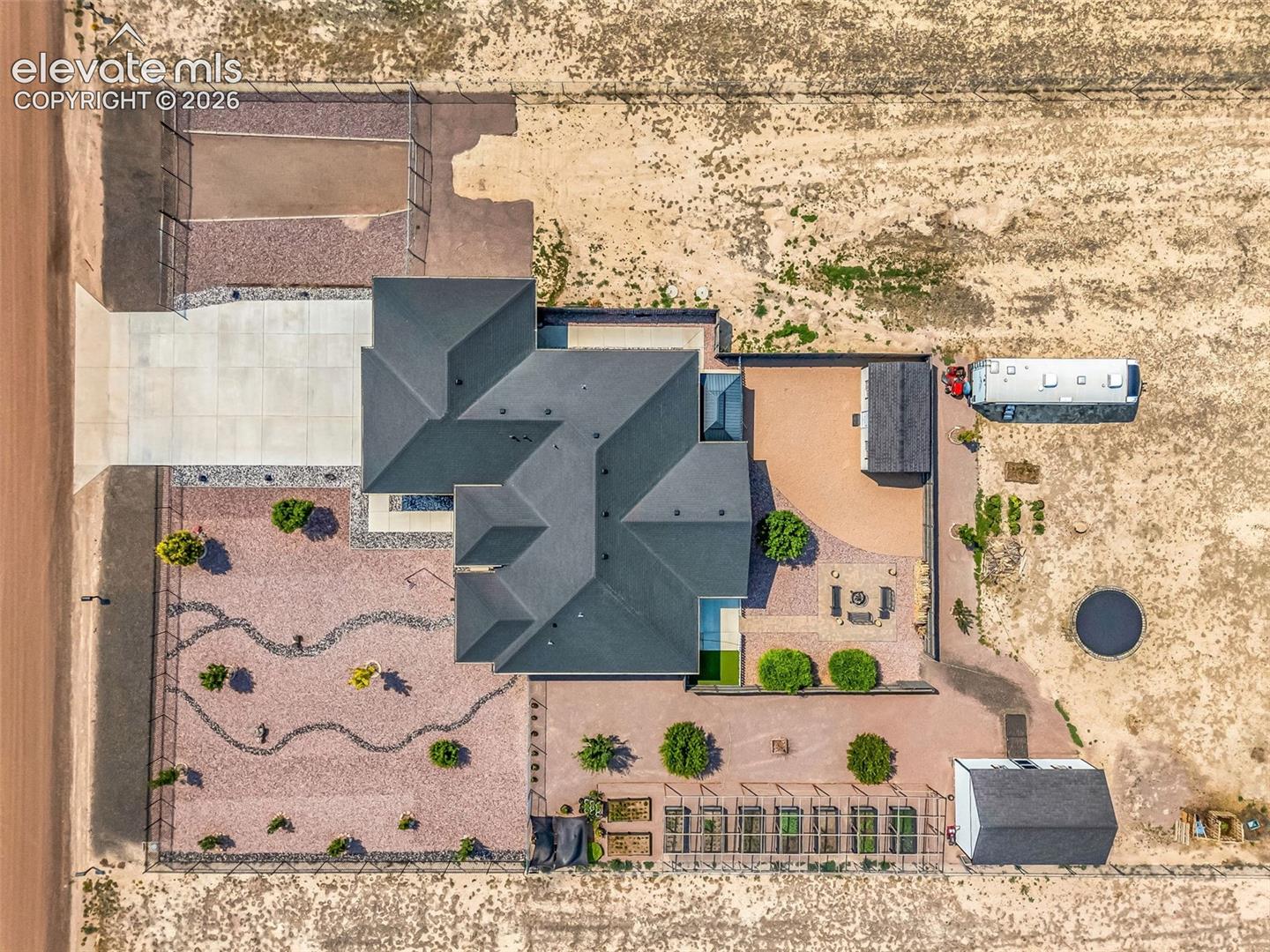 Expansive property featuring a multi-gabled main residence, a paved driveway, and a separate outbuilding