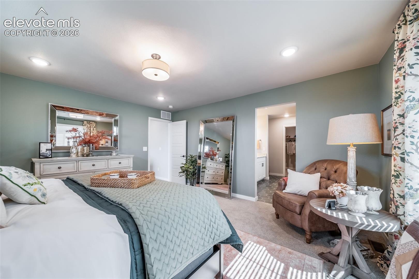 Spacious room featuring recessed lighting, a ceiling-mounted light fixture, carpeted flooring, and a doorway leading to an additional space
*Photos of a model home*